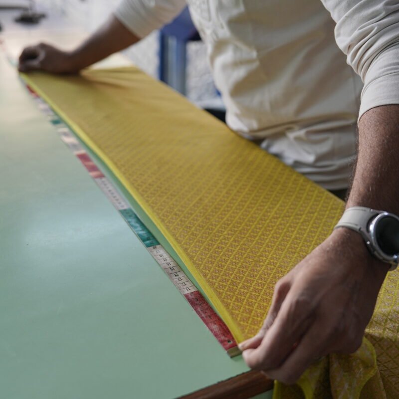 Laying out fabric by hand before cutting a made to measure garment